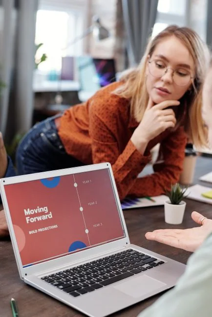 Un écran d’ordinateur moderne affichant des travaux de conception web, mettant en valeur des visuels créatifs dans un espace de travail.